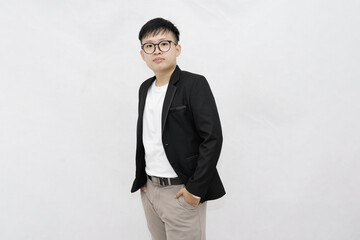 A cheerful and confident young Asian professional or student wearing a blazer and glasses, smiling against a clean white studio background