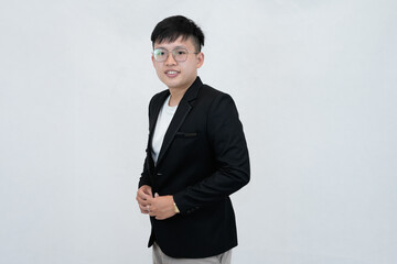 A cheerful and confident young Asian professional or student wearing a blazer and glasses, smiling against a clean white studio background