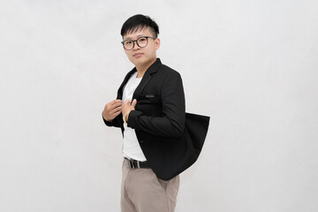 A cheerful and confident young Asian professional or student wearing a blazer and glasses, smiling against a clean white studio background