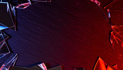 Broken glass shards with red lighting around dark background