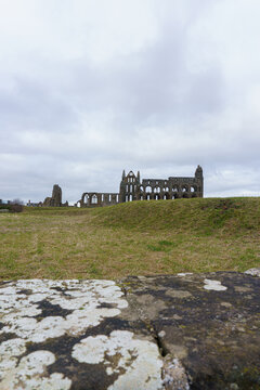 Whitby Abbey Ruins &mdash; Gothic Arches, Weathered Stone, and Lichen-Covered Foreground Under Clouded Sky