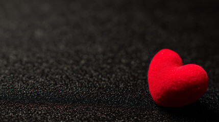 A red heart symbol stands out against a textured black background with a warm glow. wellbeing guides, coaching materials, designed for coaching and self-improvement content.