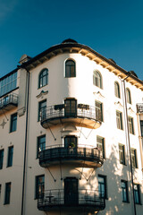 Obraz premium Elegant white building with decorative balconies and wooden window frames