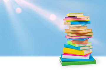 Books in multi-colored covers against the sky. Literature for children. Collection in the library. Textbooks for school college or university