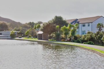 A scenic view of a pond with buildings in the background in Perranporth - Cornwall - UK