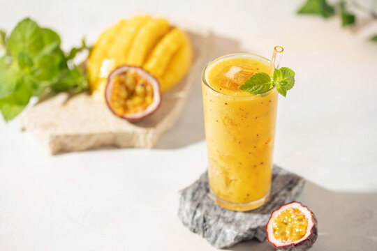 Mango passionfruit smoothie or cocktail  in drinking glass on the table. Hard light