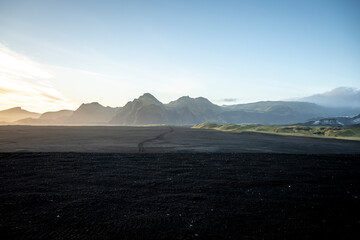 Icelandic landscape with black volcanic sand dunes at sunrise.