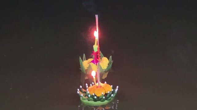 Floating krathong candle night river water lantern festival Thai culture tradition flower decoration light Loy Krathong celebration with water reflection spiritual lantern glow cultural tradition