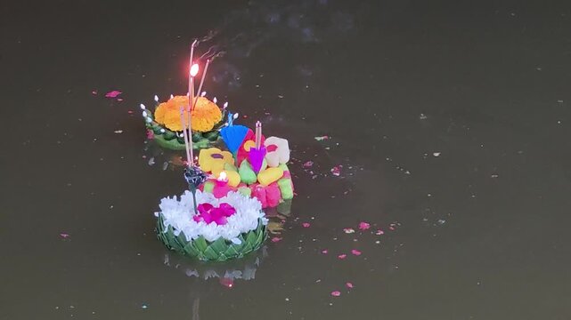 Floating loy kratong loykrathong krathong candle flower incense festival river water night reflection lotus leaf craft colorful banana petal tropical holiday ceremony peaceful Thai culture