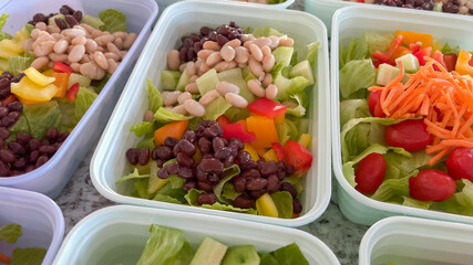 Meal prep salads with lettuce, beans, and chopped peppers