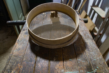 tamis à sable pour maçon sur établi.