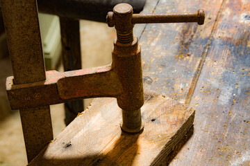 serre-joint serrant un morceau de bois sur un établi.