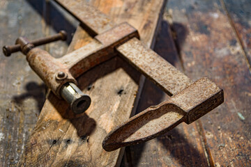 vieux serre-joint avec une planche de bois