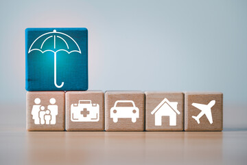 Wooden blocks showing icons for family health car home and travel with a protective umbrella symbol...