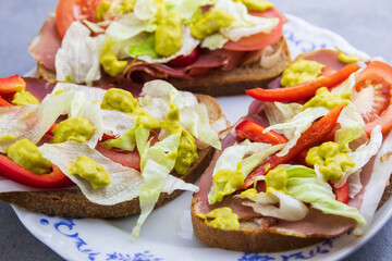Fresh vegetable lettuce, tomato and paprika on bread with ham and avocado sauce. Home made health dinner