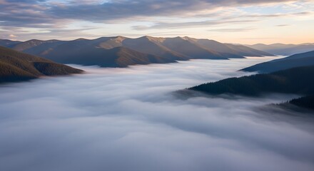 Aerial view of misty mountains and clouds during sunrise or sunset