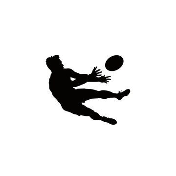 Silhouette of a rugby player kicking the ball in mid air during a dynamic game action