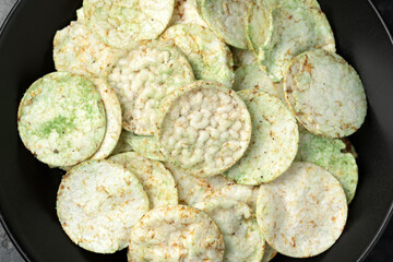 Rice wasabi chips on dark background.