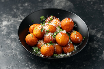 Deep fried crispy potato balls with cheese in a bowl