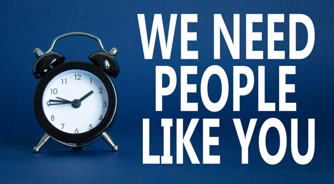 Hiring symbol. Wooden blocks with words We need People like You. Beautiful deep blue background with alarm clock. Business and Hiring concept. Copy space.