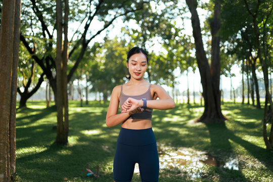 Woman checking fitness tracker during outdoor workout in park
