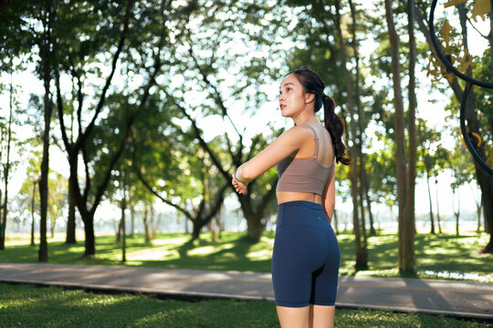 Young woman checking fitness tracker in outdoor park
