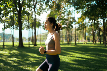 Young woman running in green park exercising outdoors