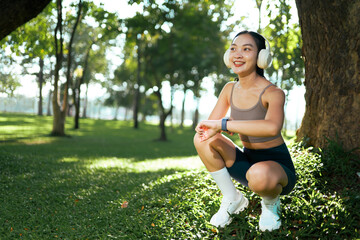 Woman exercising in park while checking smartwatch