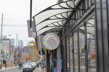 Fototapeta premium round projecting sign outside Marry Me Mochi, a donut shop, located here at 210 Augusta Av, Toronto