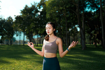 Woman meditating in park finding inner peace and wellness