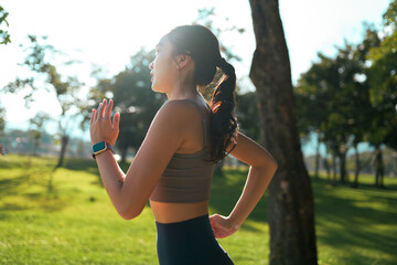 Woman running in park with smartwatch enjoying fitness