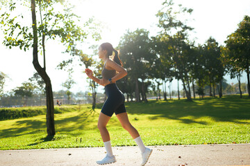 Woman jogging in park practicing healthy lifestyle