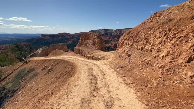 Hiking the trail to Delicate Arch in Arches National Park at dusk, warm evening light casts long shadows over the red rock landscape.