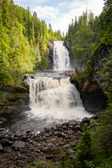 Powerful twin waterfall cascading through lush green forest
