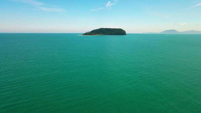 Aerial view of a small tropical island located just off the coast of Pantai Bukit Keluang in Besut, Terengganu. The island is covered in dense green forest and surrounded by vibrant turquoise waters.