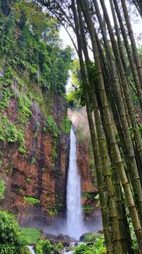 Koban Kapas Biru is a waterfall in the tropical jungles of East Java, descending from a high cliff into a lush green canyon surrounded by tropical forests with vibrant vegetation.Lumajang River. 4К