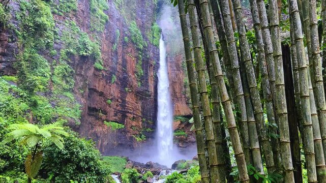 Koban Kapas Biru is a waterfall in the tropical jungles of East Java, descending from a high cliff into a lush green canyon surrounded by tropical forests with vibrant vegetation.Lumajang River. 4К