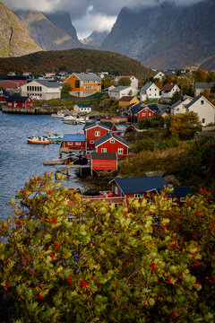 Colorful fishing village beneath dramatic Norwegian mountain landscape