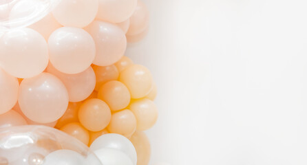 Soft pastel balloon decoration with white, peach and transparent balloons forming an elegant party backdrop on a clean white background.
