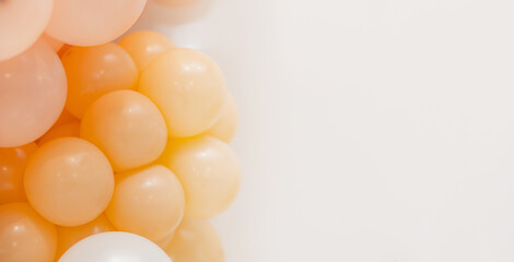 Soft pastel balloon decoration with white, peach and transparent balloons forming an elegant party backdrop on a clean white background.