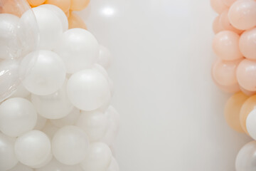 Minimal pastel balloon decoration with white, peach and transparent balloons on a clean white background, perfect for party or event themes.