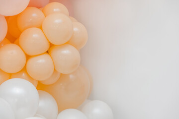 Pastel balloon decoration with peach, blush and white balloons against a clean white background. Minimal festive backdrop for celebrations and events.