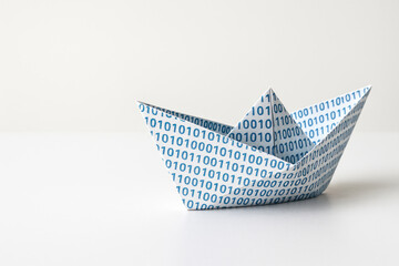 A paper boat with a binary code on a clean background. Space for text.