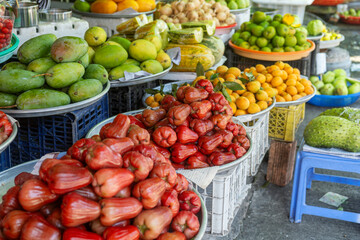 Vibrant display of fresh tropical fruits for sale at traditional food market in Phu Quoc, Vietnam. Rose apples, mangoes and loquats displayed at Vietnamese street market. Agriculture, farming