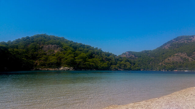 Sandy Beach and Calm Waters &mdash; Green Hills, Blue Sky, and Coastal Stillness in Old&ouml;niz, Turkey