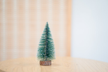 Mini Christmas tree on wooden table. Minimal trendy Christmas decoration.