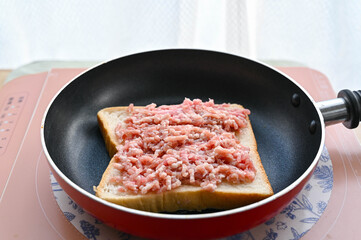 食パンにひき肉を塗りのせる