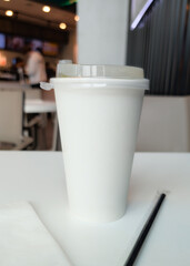 White Disposable Coffee Cup in Busy Cafe Environment