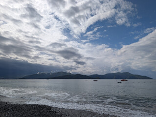 Tranquil Beach with Pebbles and Blue Sky Under Clouds