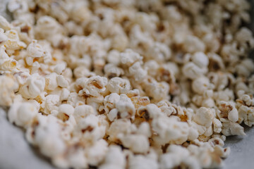 Close-up of freshly popped popcorn in a bowl, showcasing fluffy texture and golden-brown kernels, ideal for movie nights and snack time enjoyment with copy space